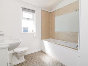 a bathroom with a tub and a toilet and a sink at Mojo in Ilfracombe +14 photos