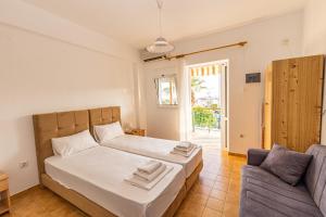 een slaapkamer met een bed en een bank bij Skioni Studios in Nea Skioni +45 foto's