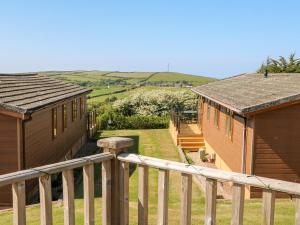 a view of two houses and a wooden railing at Mojo in Ilfracombe