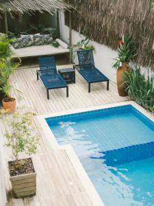 a patio with two chairs and a swimming pool at Pousada Bem Te Vi Trancoso in Trancoso
