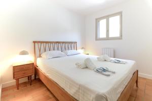 a bedroom with a large bed with white sheets and a window at SELECT'soHOME - Superbe Duplex dans le quartier Saint-Clair au Lavandou - PARCFO16 in Le Lavandou