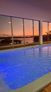 een groot zwembad met uitzicht op de oceaan bij Riviera Capitólio Hotel in Capitólio