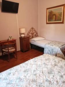 a bedroom with two beds and a desk and a tv at Sopra Le Poste in Arezzo