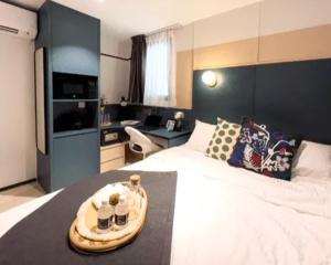 Una habitación de hotel con una cama con una bandeja. en ISA Hotel Amber Road en Singapur