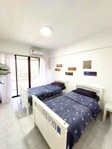 1 dormitorio con 2 camas y balcón en EC12-Georgetown-3room-PrivateHouse en Jelutong