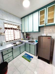 cocina con armarios azules y nevera de acero inoxidable en EC12-Georgetown-3room-PrivateHouse, en Jelutong