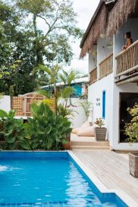 una villa con piscina di fronte a una casa di Pousada Bem Te Vi Trancoso a Trancoso