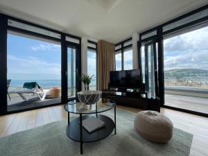 uma sala de estar com vista para o oceano em Riviera Apartments - Five Stylish Penthouse Apartments with Unrivalled Sea Views of Teignmouth, Shaldon, The Jurassic Coastline & The Teign Estuary em Teignmouth