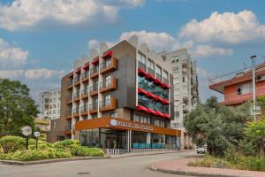 a building with red balconies on a city street at Wolf Of The City Hotel & Spa in Antalya