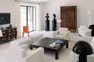 uma sala de estar com cadeiras brancas e uma mesa de centro em Le Domaine du Fortin em Ménerbes