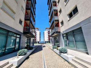 een binnenplaats tussen twee hoge gebouwen met potplanten bij RING - DeLuxe Spacious Apartment, Big Terrace, Plus Parking in Timişoara