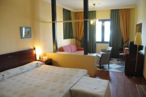 Una habitación de hotel con una cama y una sala de estar. en Hotel Puerto de Las Nieves, en Agaete
