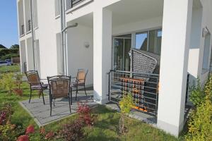 a porch with chairs and a grill on a house at Villa Antje - Ferienwohnung 03 in Göhren