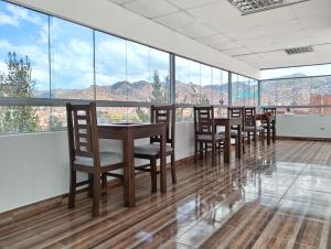 ein Esszimmer mit Tischen, Stühlen und großen Fenstern in der Unterkunft Dreams Boutique Hotel Cusco in Cusco