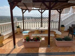 um gazebo com uma mesa e banco numa varanda em Cozy Apartment in Guardamar em Guardamar del Segura
