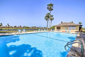 a large swimming pool with chairs and a house at Laguna Vista Vacation Rental with Pool Access! in Laguna Vista