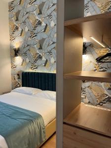 a bedroom with a bed and a wall with a mural at Lolli Palace Hotel in Sanremo