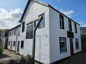 a white building with a sign on the side of it at Burnside in Tighnabruaich