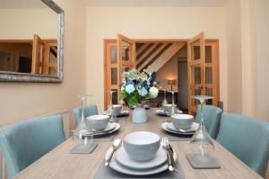 a dining room table with a vase of flowers on it at Burnside in Tighnabruaich