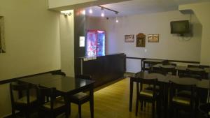 a dining room with tables and chairs and a television at Koten Hotel in Buenos Aires