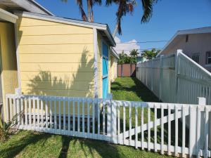 a white picket fence in front of a house at Waterfront Boat Lift Bungalow in St Pete Beach