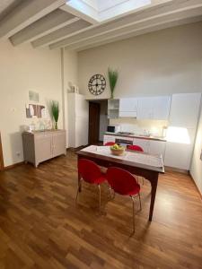 een keuken met een tafel en rode stoelen in een kamer bij Mini Loft Castello in Thiene