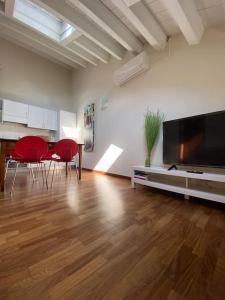 een woonkamer met rode stoelen en een flatscreen-tv bij Mini Loft Castello in Thiene