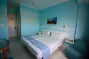 1 dormitorio azul con 1 cama y 1 silla en Cala Bona y Mar Blava, en Ciutadella