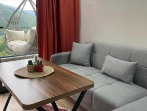 a living room with a couch and a table at Green Hill Apart in Ardeşen