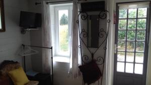 a room with a door and a television and a window at white house in Saint-Germier