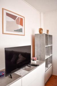 a living room with a large flat screen tv on a white cabinet at 3pko City center apartment in Banja Luka