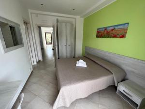 ein Schlafzimmer mit einem Bett und einer grünen Wand in der Unterkunft B&B PRIXIS in Prizzi