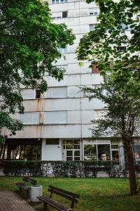 a building with two benches in front of a building at 3pko City center apartment in Banja Luka