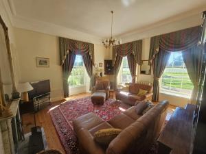 a living room with a couch and a tv at Sloley Hall in Tunstead