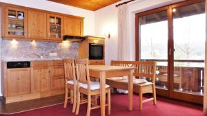een keuken met een houten tafel en stoelen en een wastafel bij Ferienhaus Waldwinkl in Grainau