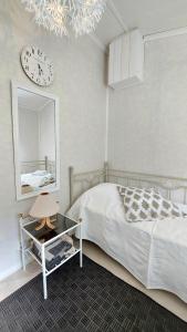 a bedroom with a bed and a mirror and a clock at Kulttuurikartano Pekan Pirtit in Haapavesi