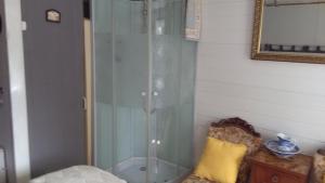 a glass shower in a corner of a room at white house in Saint-Germier