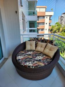a wicker couch sitting on a balcony at Apto temporada Cabo Frio in Cabo Frio