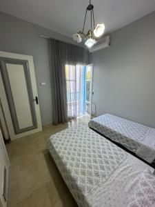 - une chambre avec 2 lits et une fenêtre dans l'établissement APPARTEMENT RAYHAN Yasmine Hammamet, à Hammamet