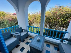 - une terrasse couverte avec 2 chaises, une table et des fenêtres dans l'établissement APPARTEMENT RAYHAN Yasmine Hammamet, à Hammamet