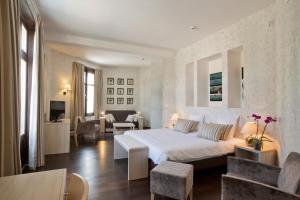 a bedroom with a large bed and a living room at Logis Les Loges du Parc in La Roche-Posay