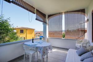 un tavolo e sedie su un balcone con vista di Trilo Mare a Budoni