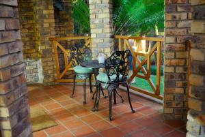 un patio con 3 sillas y una mesa en un porche en 20 on Visarend en Malelane