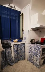 - une cuisine avec du carrelage bleu et blanc sur les comptoirs dans l'établissement Casa Franchi, à Catane