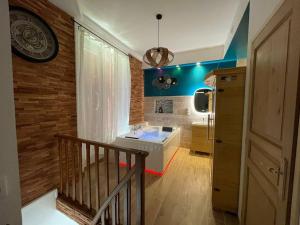 ein Badezimmer mit Waschbecken und eine Treppe mit blauen Wänden in der Unterkunft Suite d'amour et détente jacuzzi, sauna et massage in Chartrettes