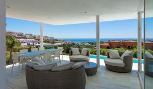 a patio with a table and chairs and the ocean at Villa Dona Julia 2410 Golf and Sea views in Casares