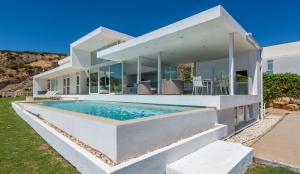 an exterior view of a house with a swimming pool at Villa Dona Julia 2410 Golf and Sea views in Casares
