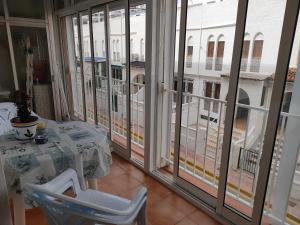a room with large windows and a table on a balcony at Casas Holiday - Playa la Mata Laredo in La Mata