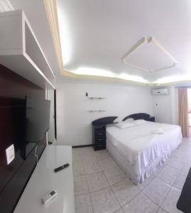 a bedroom with a bed and a flat screen tv at Riverfront Retreat Prime Location Apartment with Stunning Views of the RioNegro in Manaus