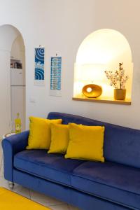 a blue couch with yellow pillows in a living room at Casa Borgo Sant'Angelo in Ischia